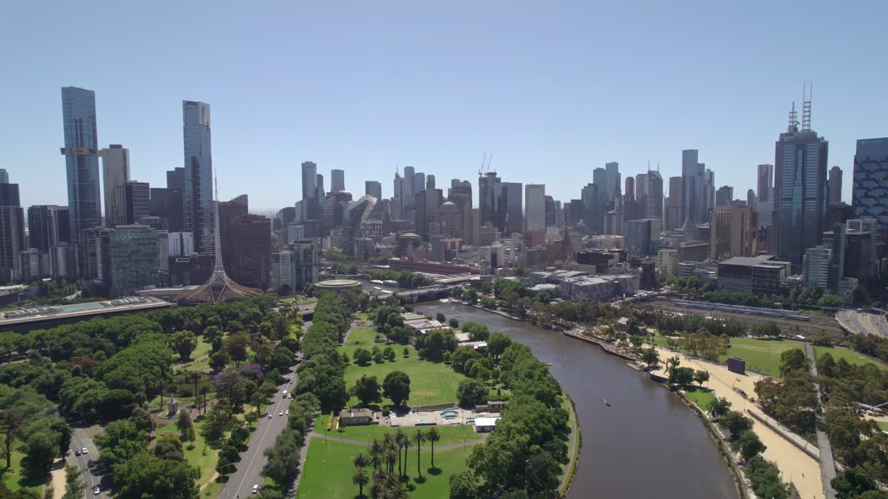 Vista drone inversa in una giornata di sole del fiume Yarra in primo piano e dello skyline di Melbourne in lontananza, Victoria, Australia. Dicembre 2025.