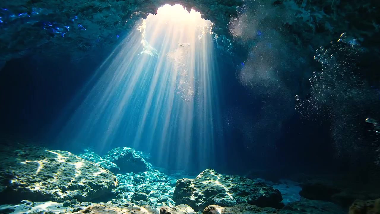 Sunlight Rays Piercing Through Underwater Cave into Deep Blue Water