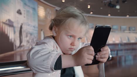 little child is staring at smartphone screen