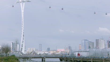 teleféricos que viajan sobre el río támesis en londres con el parque olímpico al fondo