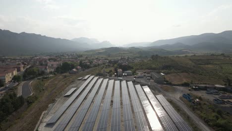 Solar-panels-reflect-sun-in-hazy-green-rural-France-mountain-valley