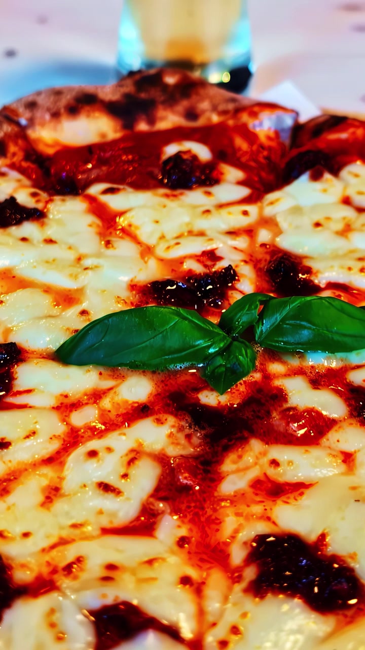Pizza al formaggio cotta nel forno a legna abbinata a una birra fresca in un'accogliente atmosfera da caffè