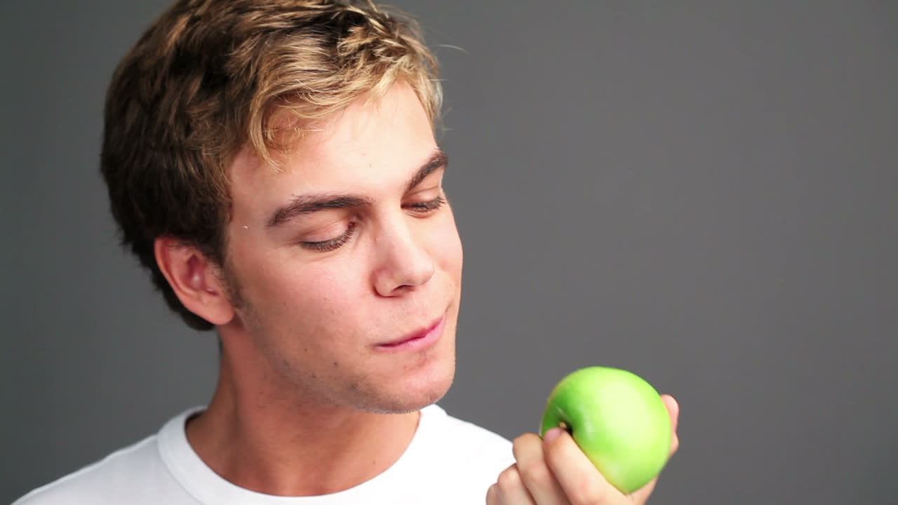 hombre sano comiendo manzana verde