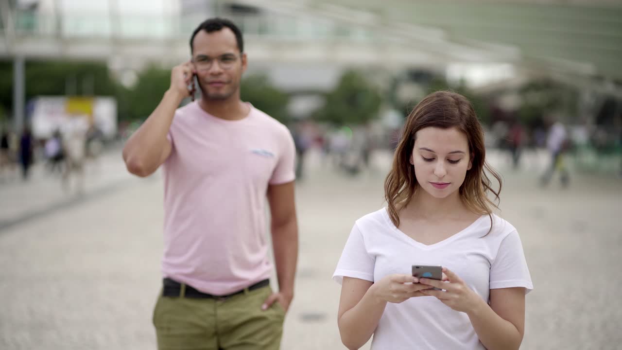 vista frontal de una joven pacífica enviando mensajes de texto durante un paseo