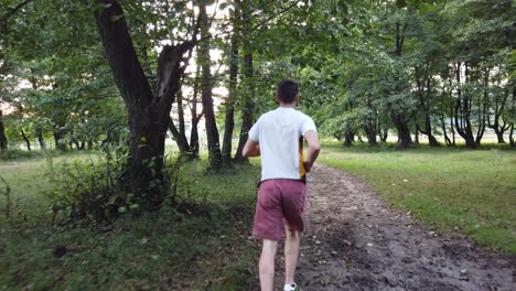 Junger-Kaukasischer-Mann,-Der-Im-Sommer-Auf-Einem-Pfad-Im-Wald-Läuft