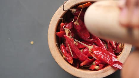 crushing dried red chilies in a mortar and pestle