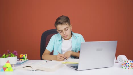 boy looking at laptop is unmotivated and bored.