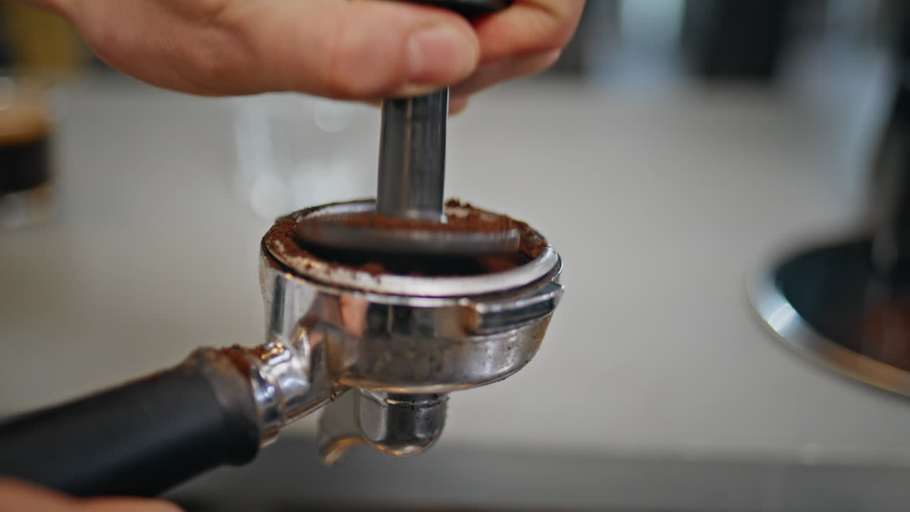 Barista hands preparing cappuccino in cafeteria with espresso machine closeup