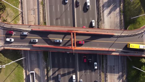 Ascending-shot-of-a-bridge-over-Panamericana-highway-in-Buenos-Aires,-Argentina-with-buses,-trucks-and-cars-plying-on-it