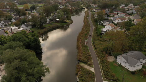 An-aerial-drone-shot-over-a-reflective-pond-on-a-cloudy-afternoon