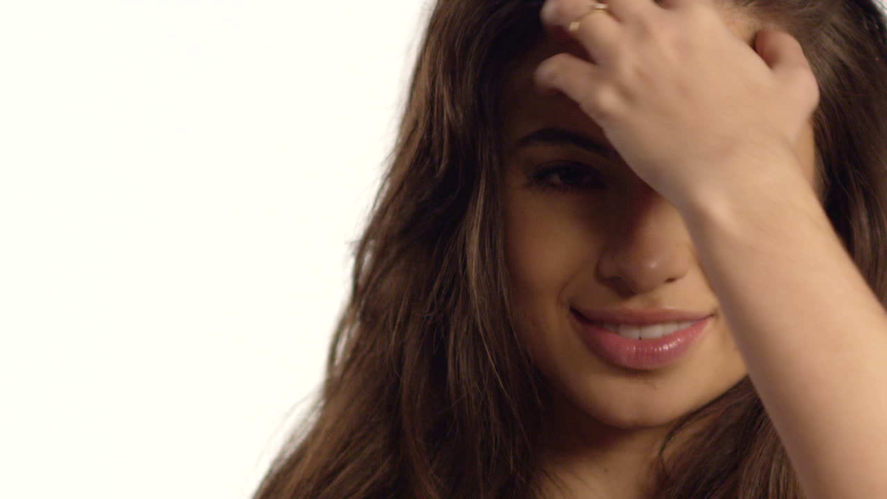 cu 웃는 젊은 여자가 머리를 만진다