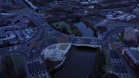 Vista-Aérea-Mirando-Hacia-El-Centro-De-La-Ciudad-Canal-Rotonda-Infraestructura-Calles-Suburbanas-Tráfico-Al-Amanecer-Lento-Dolly-Izquierda