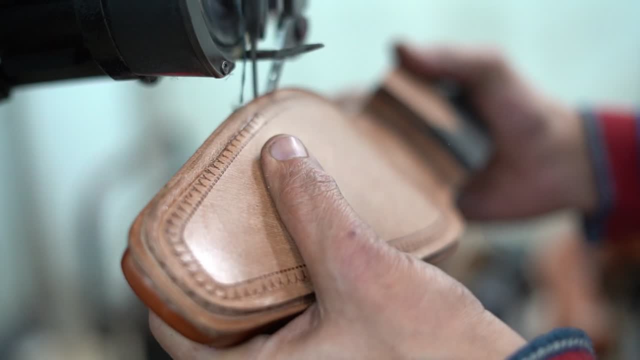 a craftsman handmade a shoe by a machine, close up shot, insert shot