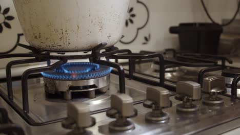 Hand-rotates-stove-switch-and-ignites-gas-fire-cooking