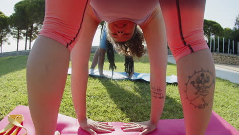 vista posterior de una mujer caucásica enfocada inclinándose hasta las piernas