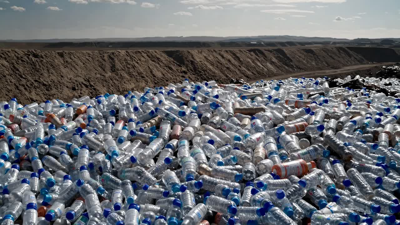 Campo lungo di una discarica piena di bottiglie di plastica, che mette in evidenza l'inquinamento ambientale