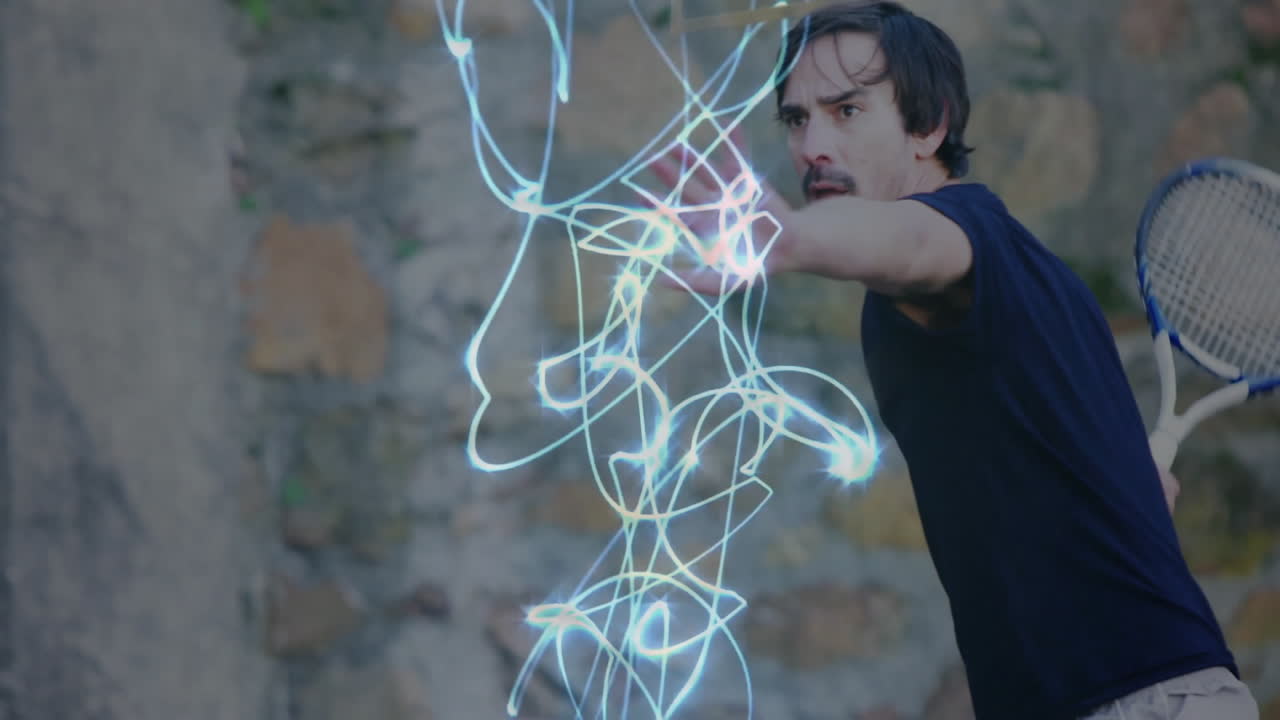 Man holding tennis racket reaching toward neon energy trails against wall, showcasing technology