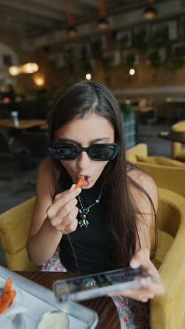 teenager enjoying a meal and using her smartphone in a cafe