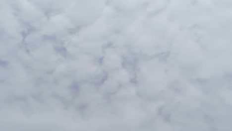 vista vertical de mirar hacia el cielo azul claro con nubes de polvo gris y blanco