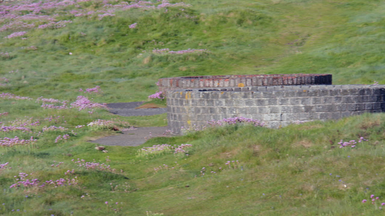 Mid panning shot of Derelict military infrastructure at the headland at Hafan y Môr on Pen-y-chain, Pwllheli