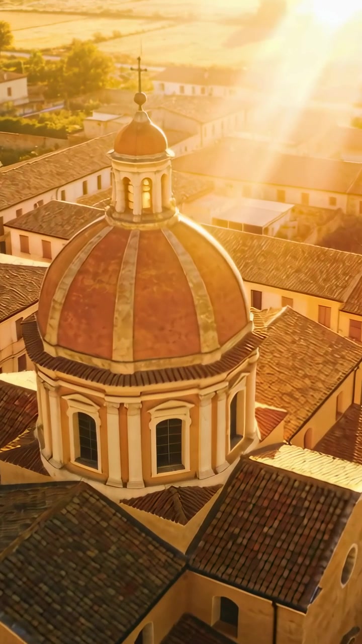 Video verticale: Telecamera drone che scivola avvicinandosi alla cupola di una chiesa, città mentre un bagliore solare illumina la croce.