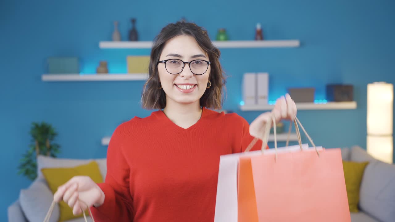 una joven feliz haciendo compras mirando a la cámara.