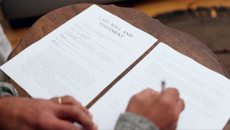 Hands,-writing-and-will-documents-on-table