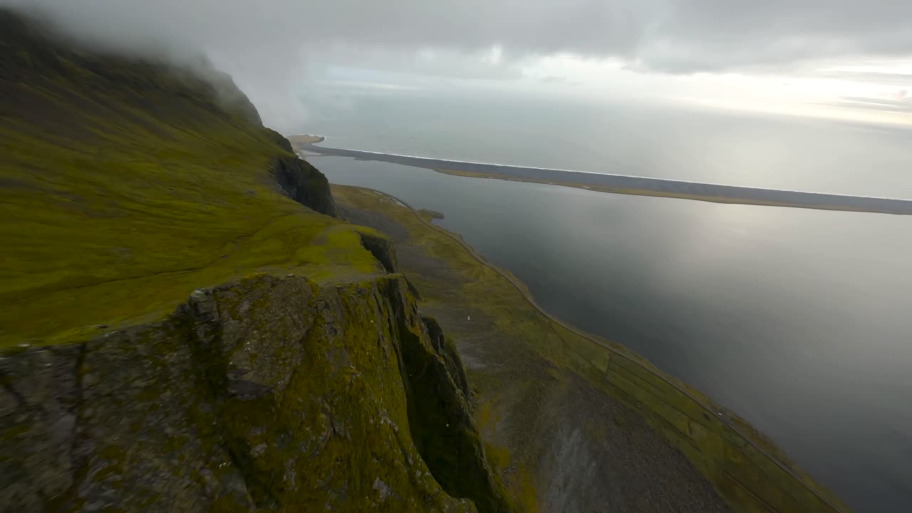 panorámica fpv aérea de un acantilado costero de roca volcánica en en la zona rural de islandia