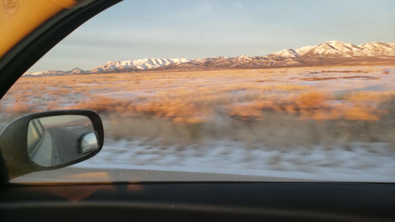 Paesaggio leggermente innevato visto da un'auto in movimento.