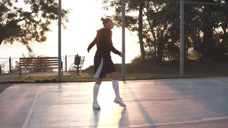 Young-Fit-Woman-In-Hoodie-And-Shorts-Warming-Up-In-Morning-On-Basketball-Court