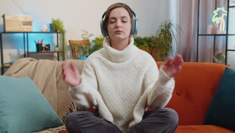 Woman breathes deeply eyes closed meditating with concentrated thoughts peaceful mind at home