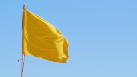 yellow flag against the blue sky