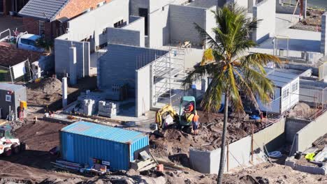 drone footage captures workers and machinery at a bustling construction site under bright daylight in gold coast, australia