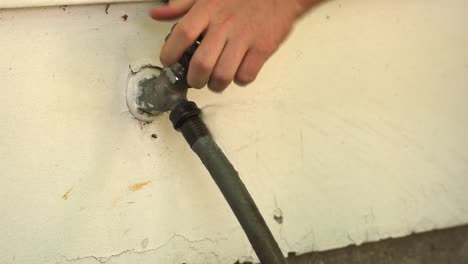 a individual turns off a sprinkler on a hot summer day