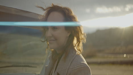 woman by a vintage car at sunset