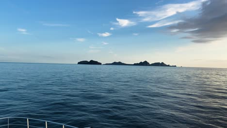 Heimaey-island-near-Iceland-on-sunny-day,-view-from-moving-vessel