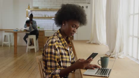 mujer usando teléfono inteligente y portátil en casa