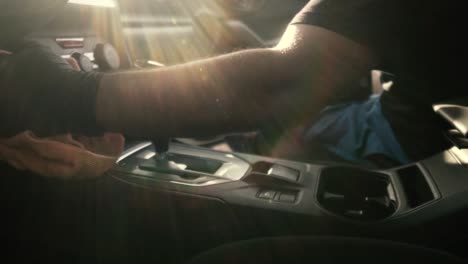 Close-up-of-a-male-wearing-black-gloves-cleaning-a-white-car-with-black-interior-with-a-microfiber-cloth-in-slow-motion