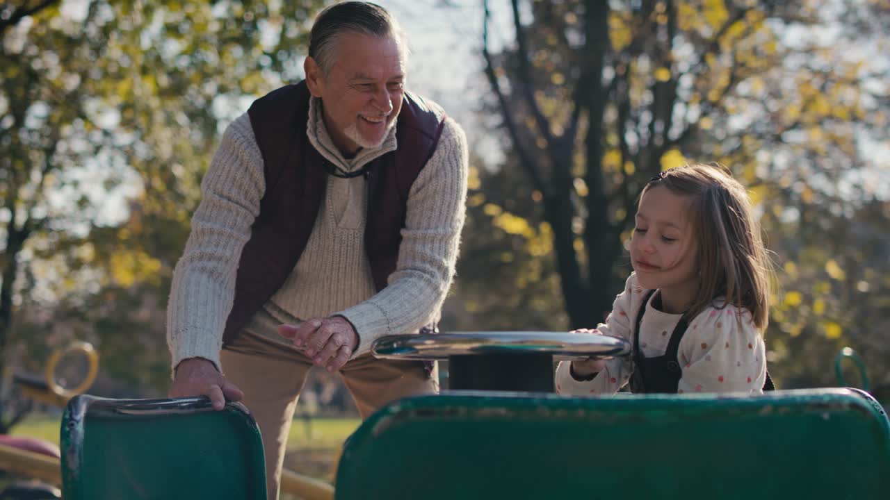 abuelo caucásico jugando con su nieta en el parque