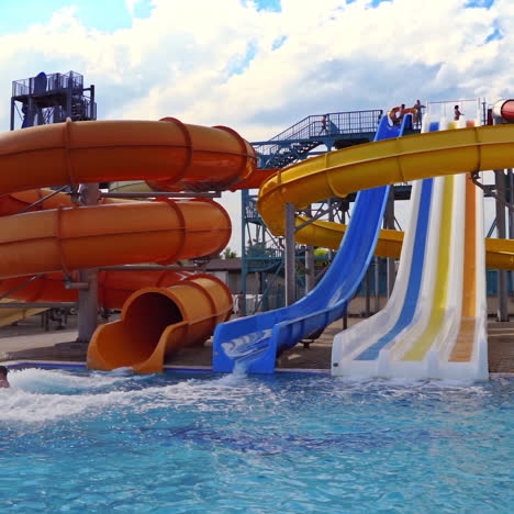 beautiful aquapark under blue sky. colorful slides with clear water in the swimming pool outdoors. joyful entertainment in the open air in a summertime.