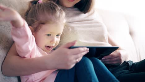 mother-and-sweet-daughter-are-sitting-on-the-couch