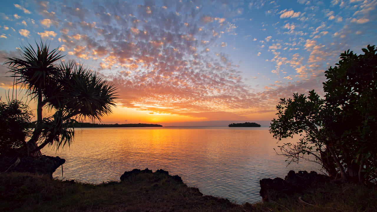 tranquilo y vibrante lapso de tiempo de día a noche sobre una bahía aislada de isla de pinos, nueva caledonia