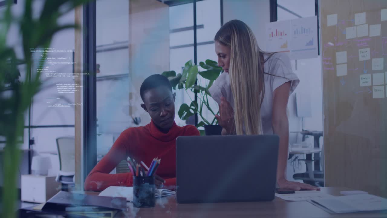 Seated woman showing map by reviewing laptop noting data while colleague guiding business analysis