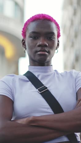 portrait of a confident person with pink hair in an urban setting