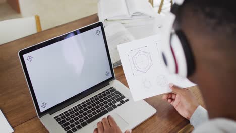 hombre afroamericano con auriculares y usando una computadora portátil con espacio de copia