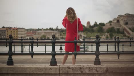 Woman-in-red-waiting-for-train-in-Budapest,-Hungary