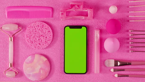 pink beauty flat lay with green screen phone