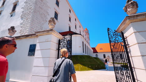 bratislava, slovakia, 2 june 2025: walking through the gate to the territory of the beautiful castle. low angle view at the exterior of the bratislava castle in slovakia
