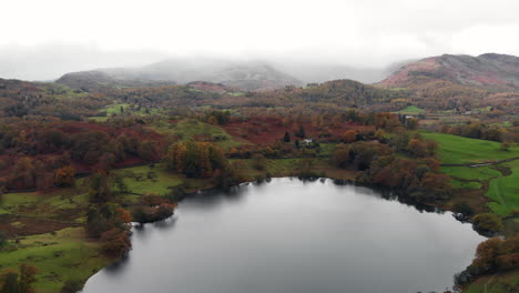 Aerial-footage-above-Loughrigg-Tarn-in-Cumbria-looking-over-to-Windermere