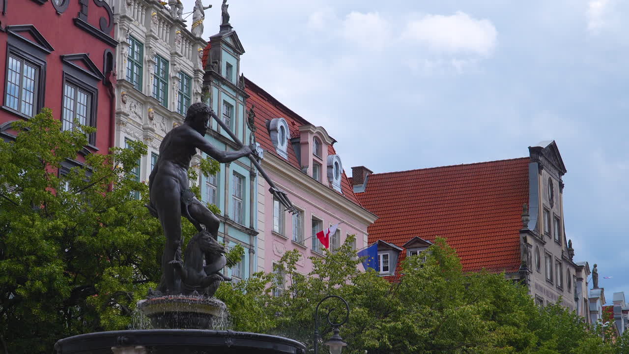 Neptune Fountain with colorful historic tenement houses in Gdańsk in the background